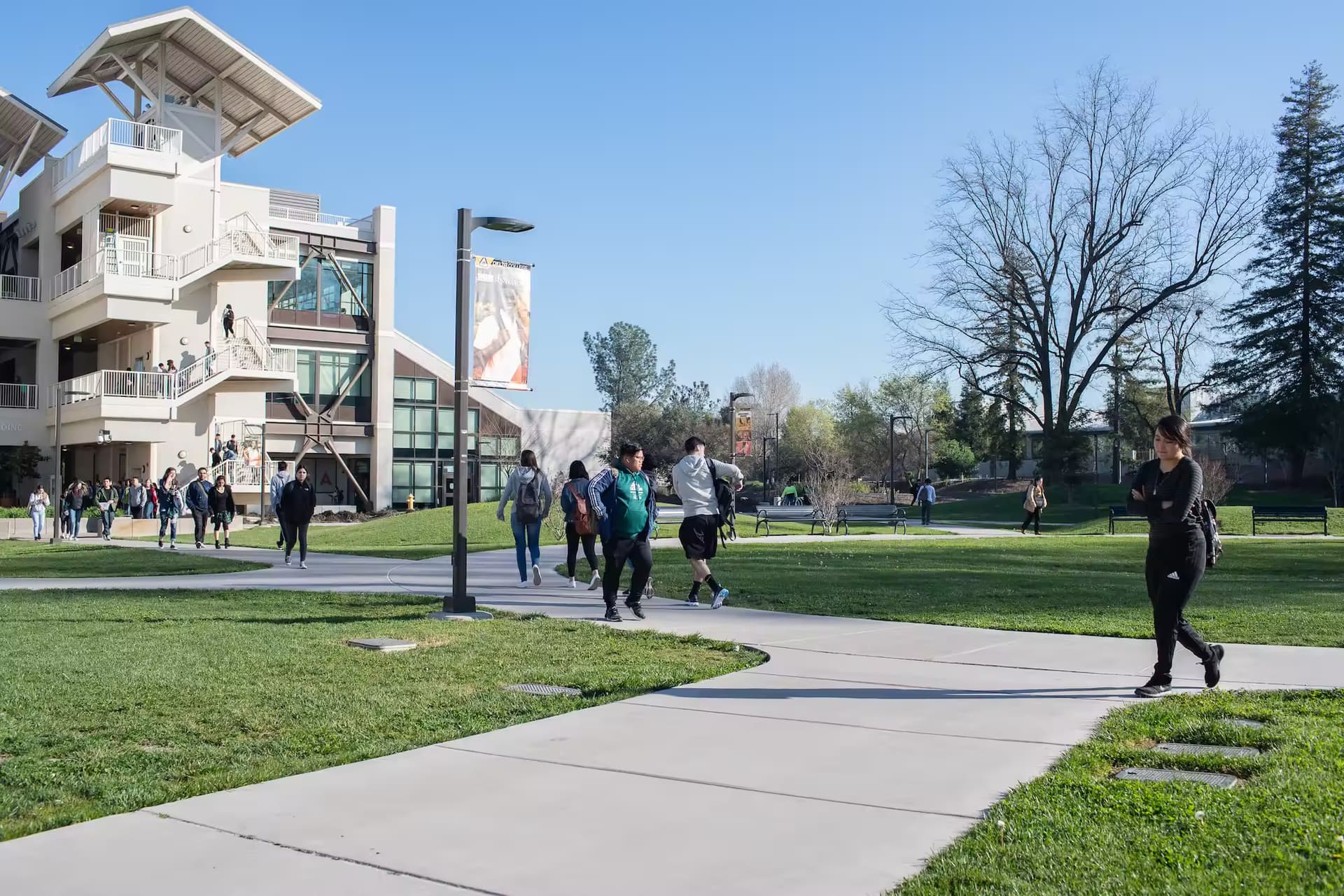 Students traversing a college campus during a sunny day